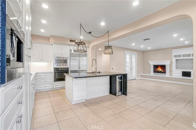 26803 Brookhollow Dr, Valencia, CA 91355 - kitchen featuring built in appliances, light tile patterned floors, a sink, dark countertops, and white cabinets