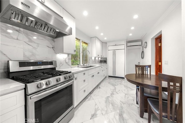 kitchen featuring gas range, a wall mounted air conditioner, range hood, paneled refrigerator, and a sink