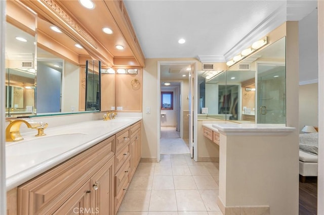 ensuite bathroom featuring tile patterned floors, a sink, visible vents, and crown molding