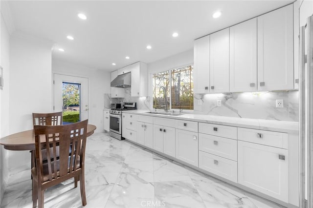 kitchen featuring recessed lighting, under cabinet range hood, backsplash, a wealth of natural light, and stainless steel gas stove