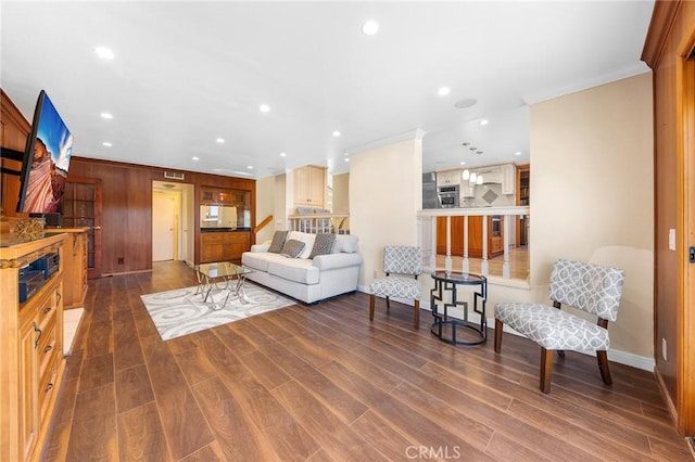 living room featuring crown molding, baseboards, wood finished floors, and recessed lighting