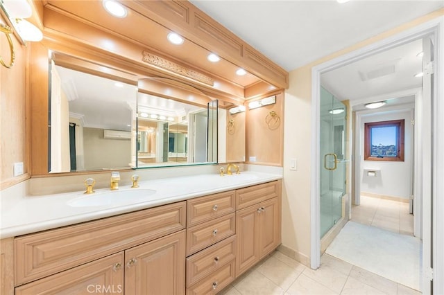 full bathroom with double vanity, tile patterned flooring, a shower stall, and a sink