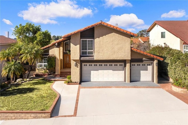 view of front of property featuring driveway, a tile roof, and stucco siding