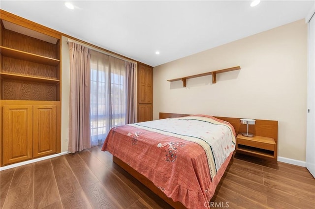 bedroom featuring baseboards, wood finished floors, and recessed lighting