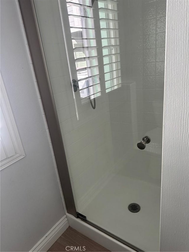 full bath featuring a stall shower and baseboards