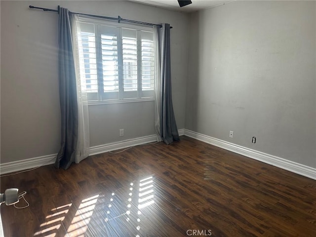 empty room with baseboards and wood finished floors