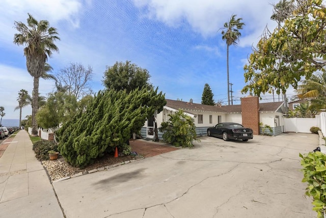 view of front of house featuring fence and concrete driveway