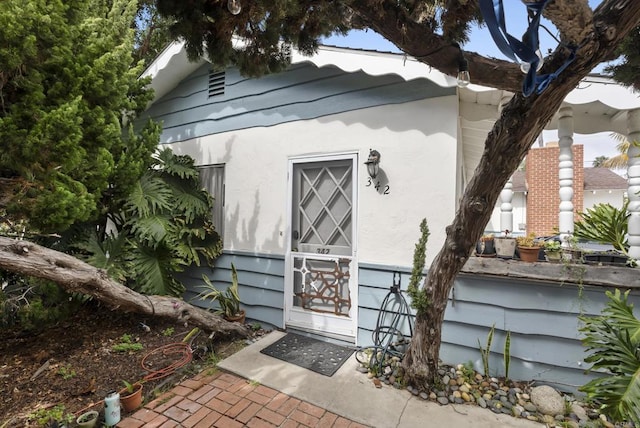 property entrance featuring stucco siding