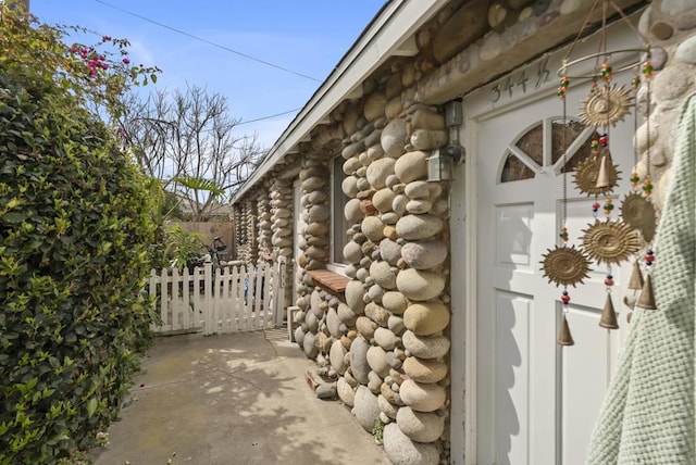 exterior space with a gate, fence, and log siding