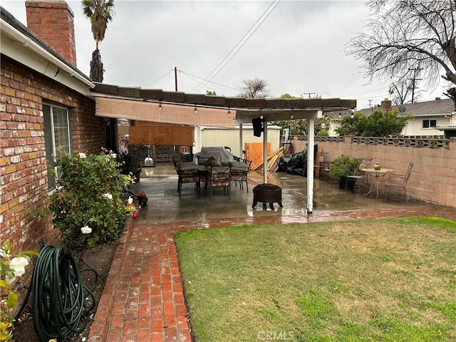 view of yard with a patio, an outdoor fire pit, and fence