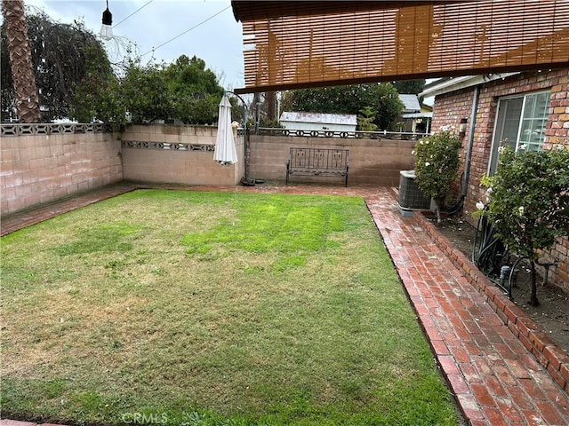 view of yard with central air condition unit and a fenced backyard