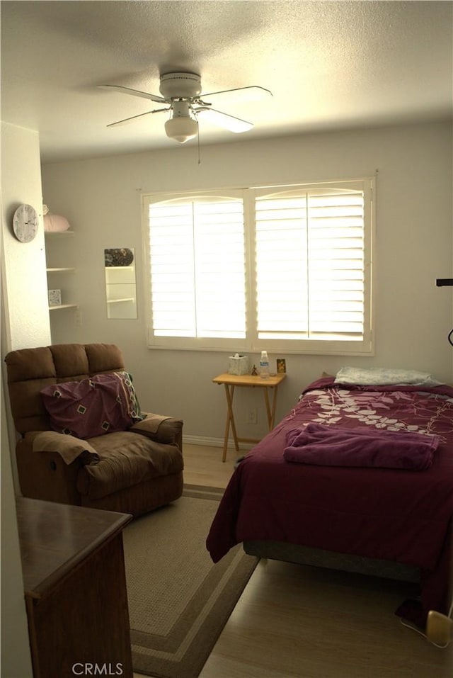 bedroom featuring multiple windows, a textured ceiling, and ceiling fan