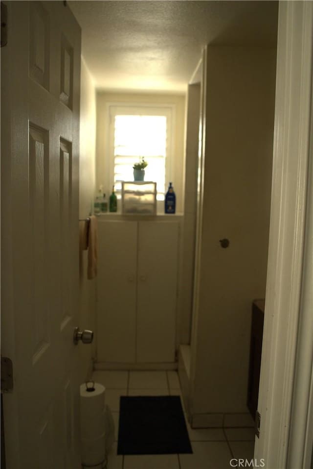 bathroom with tile patterned flooring and a textured ceiling