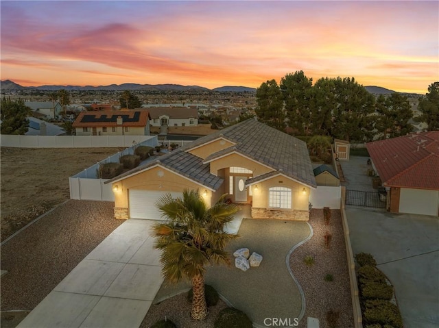 view of front of home featuring a gate, fence, a mountain view, and concrete driveway