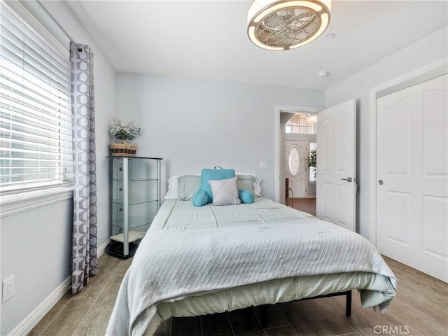 bedroom with light wood-type flooring and baseboards