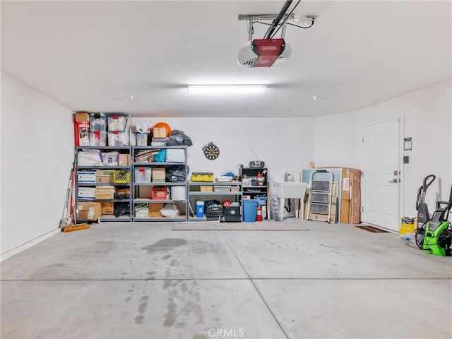 garage with a garage door opener and a sink