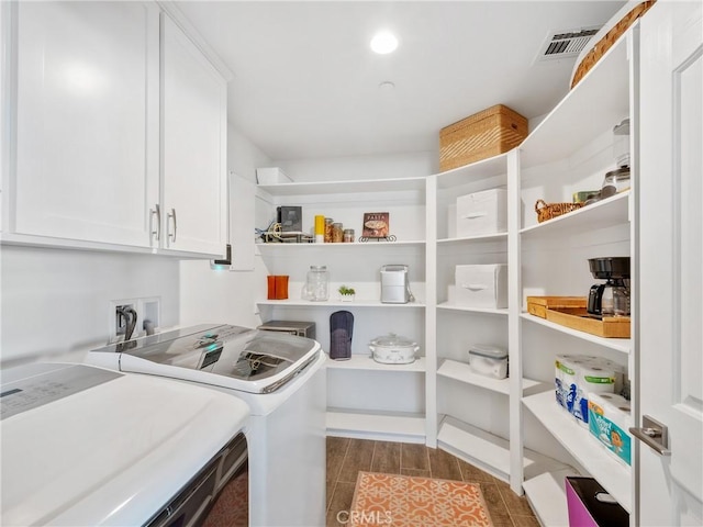 pantry with visible vents and washing machine and clothes dryer