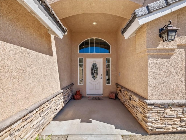 entrance to property featuring stucco siding