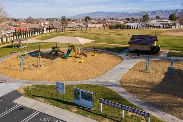 surrounding community with a mountain view, playground community, a lawn, and a residential view