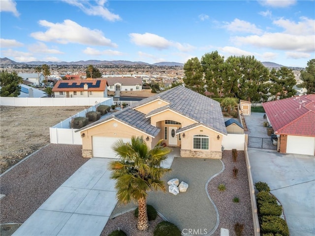 view of front facade with fence private yard, a mountain view, driveway, a gate, and stucco siding