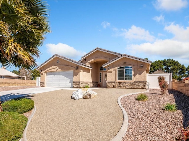 view of front facade with stucco siding, fence, a garage, stone siding, and driveway