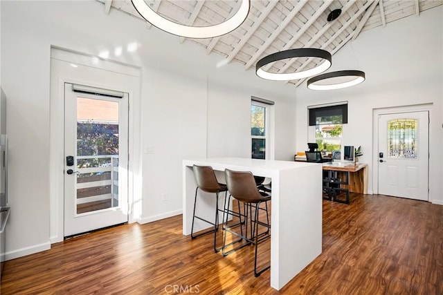 bar with dark wood-style floors, wood ceiling, vaulted ceiling with beams, and baseboards