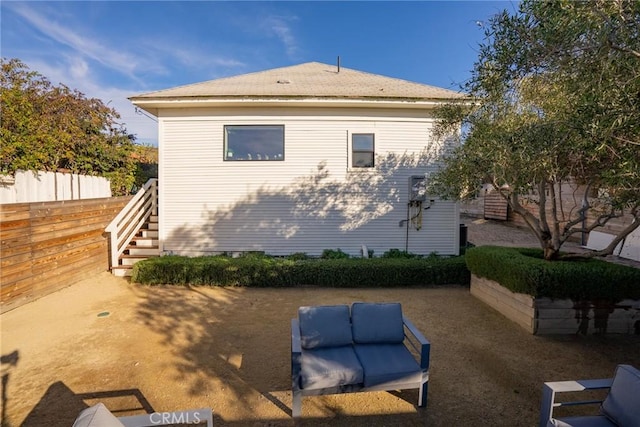 view of home's exterior featuring fence and stairway