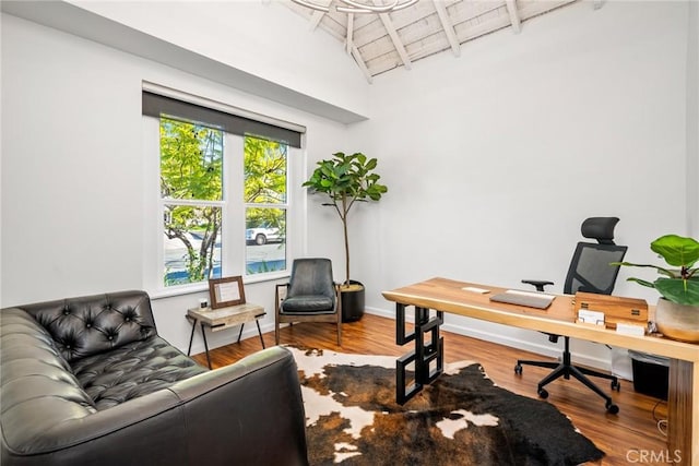 office space with lofted ceiling with beams, wood finished floors, wood ceiling, and baseboards