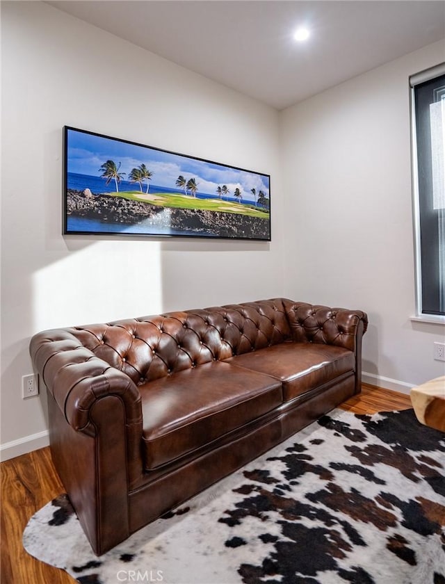 living area featuring baseboards and wood finished floors