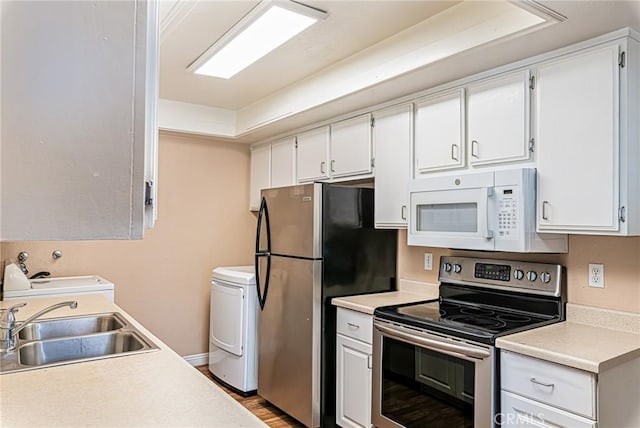 kitchen featuring stainless steel appliances, washer / clothes dryer, light countertops, and a sink