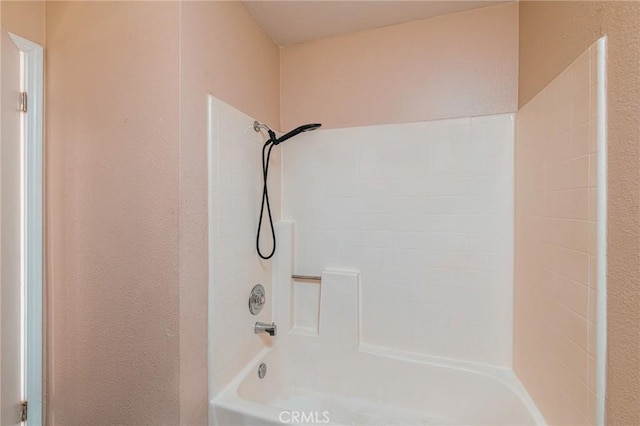 full bath featuring tub / shower combination and a textured wall