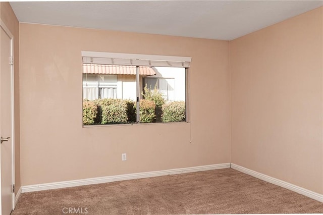 carpeted empty room featuring baseboards