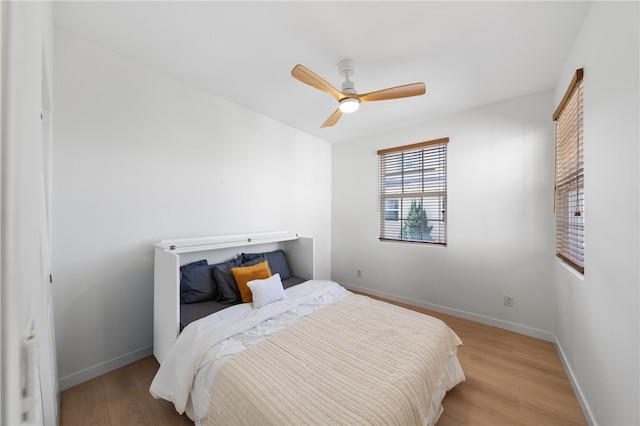 bedroom featuring light wood-type flooring, baseboards, and a ceiling fan