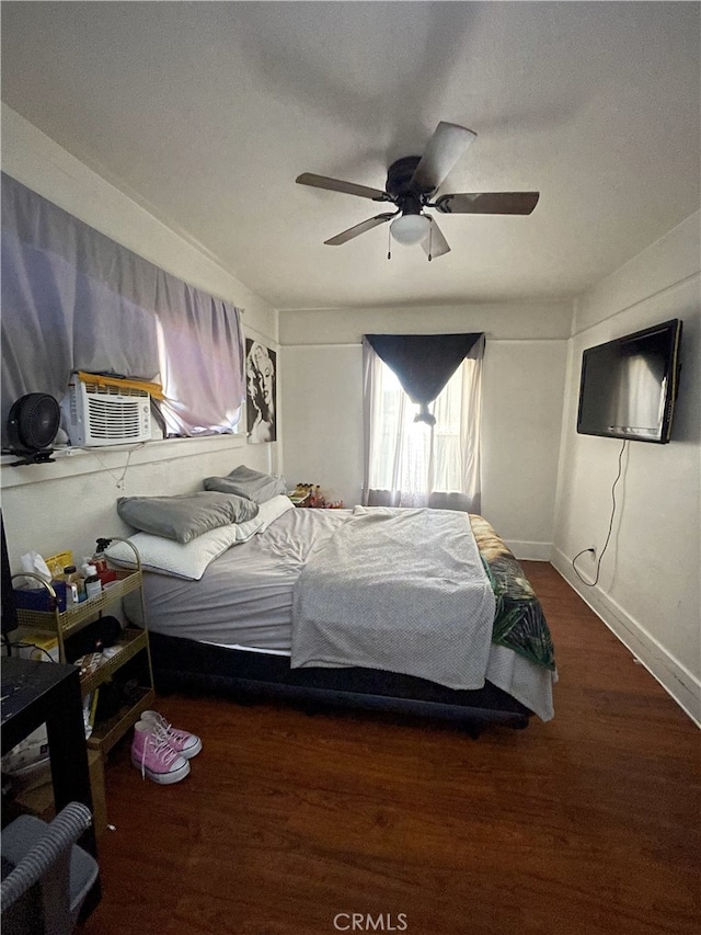 bedroom featuring ceiling fan, wood finished floors, and baseboards