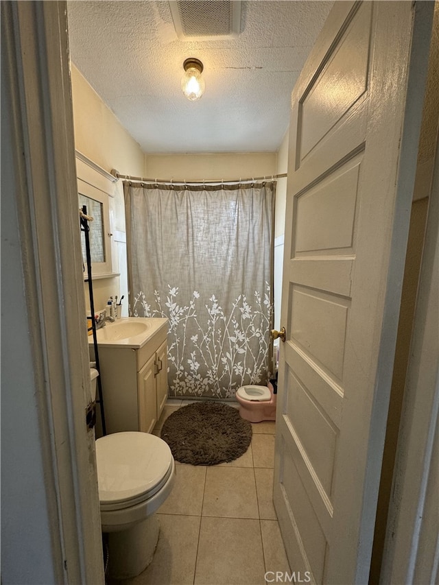 full bathroom with visible vents, a shower with shower curtain, toilet, tile patterned floors, and vanity