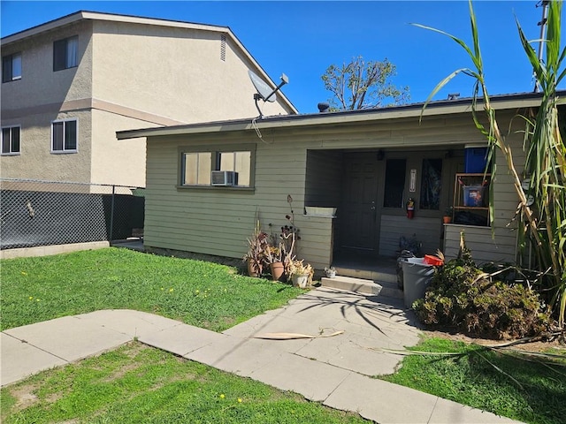 view of front of home with a front yard, fence, and stucco siding