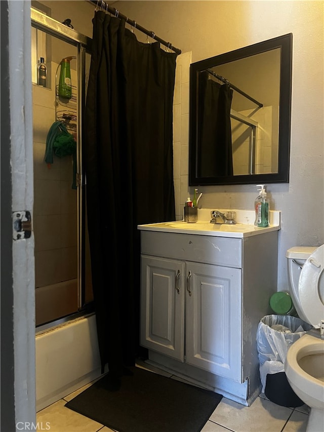 bathroom featuring tile patterned floors, vanity, toilet, and shower / bath combo with shower curtain