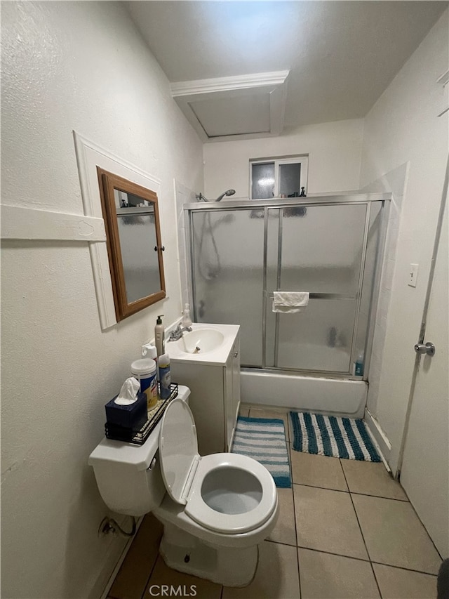 bathroom with toilet, tile patterned flooring, enclosed tub / shower combo, and vanity