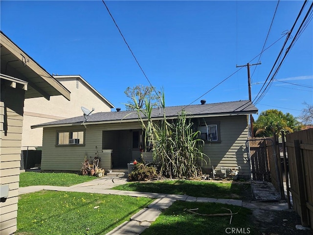 view of front of house with a front lawn and fence