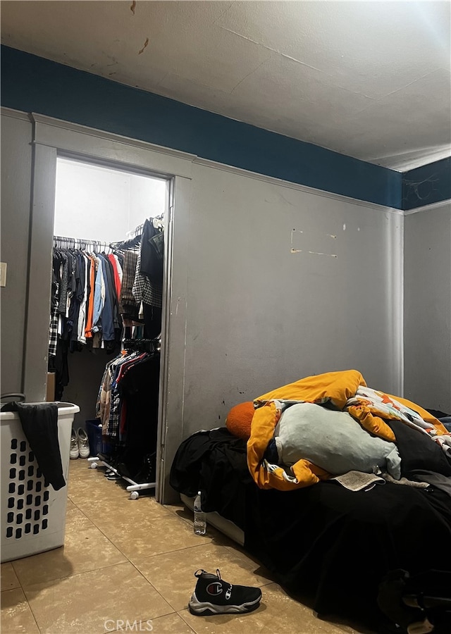 bedroom featuring concrete flooring, a closet, and a walk in closet