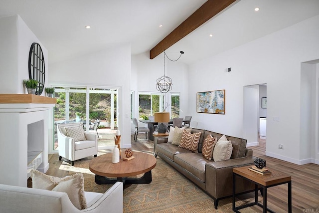 living area with high vaulted ceiling, beamed ceiling, wood finished floors, and a healthy amount of sunlight