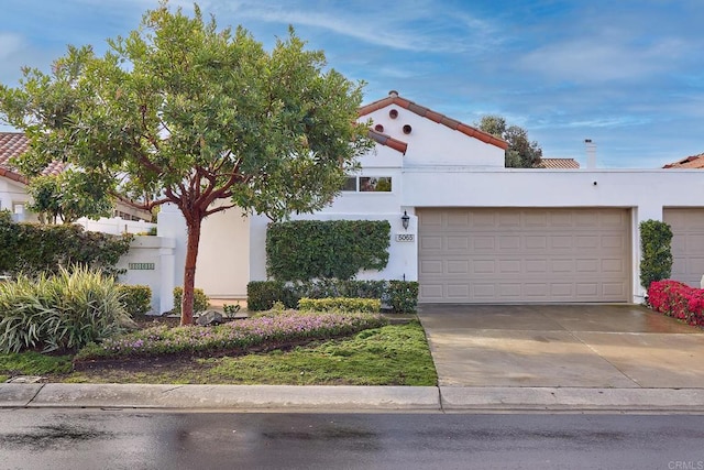 view of front of property with a garage, concrete driveway, and stucco siding