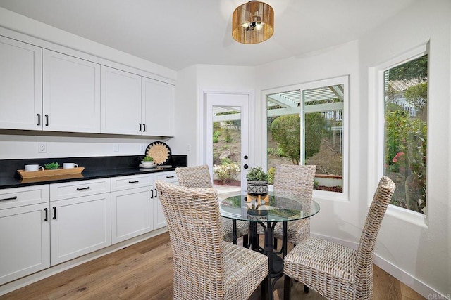 dining space featuring light wood finished floors and baseboards