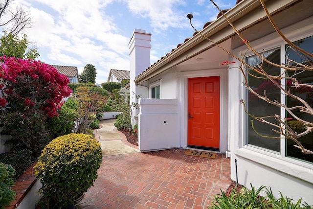 entrance to property with stucco siding and a patio