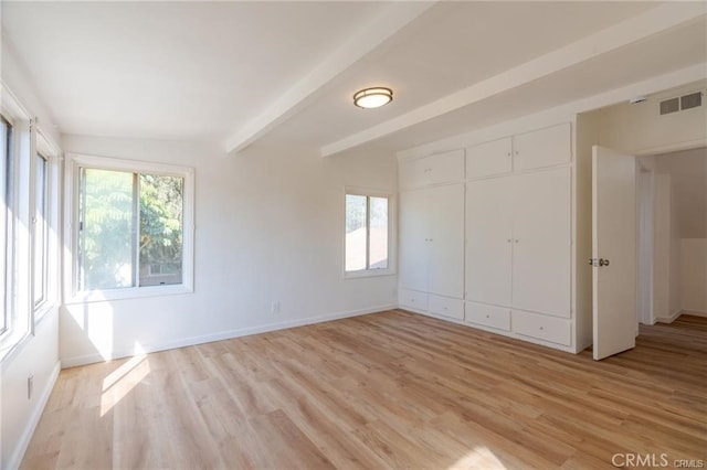 unfurnished bedroom featuring visible vents, beamed ceiling, light wood-style flooring, and baseboards