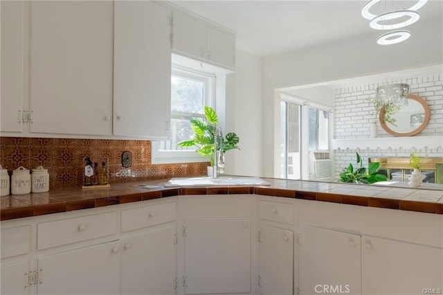 kitchen featuring a sink, white cabinets, and decorative backsplash