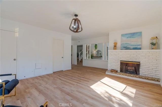 unfurnished living room with a fireplace, wood finished floors, and baseboards