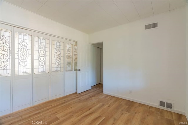 unfurnished bedroom with light wood finished floors, baseboards, and visible vents