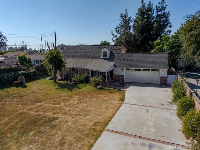 view of front of home featuring a shingled roof, fence, a garage, driveway, and a front lawn