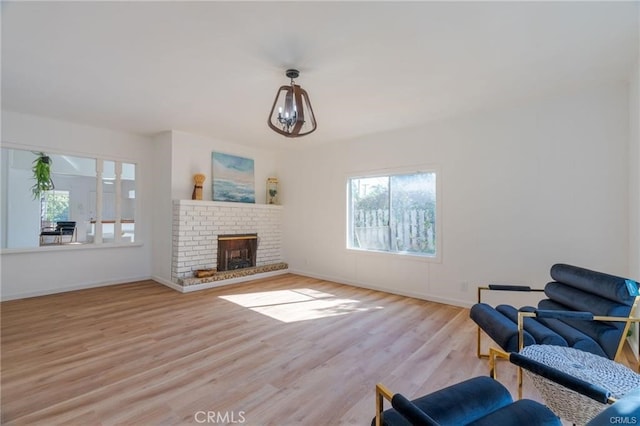 living room featuring light wood-type flooring, a fireplace, and baseboards